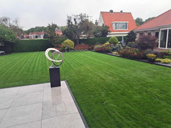 moderne sculptuur van rvs in een tuin
