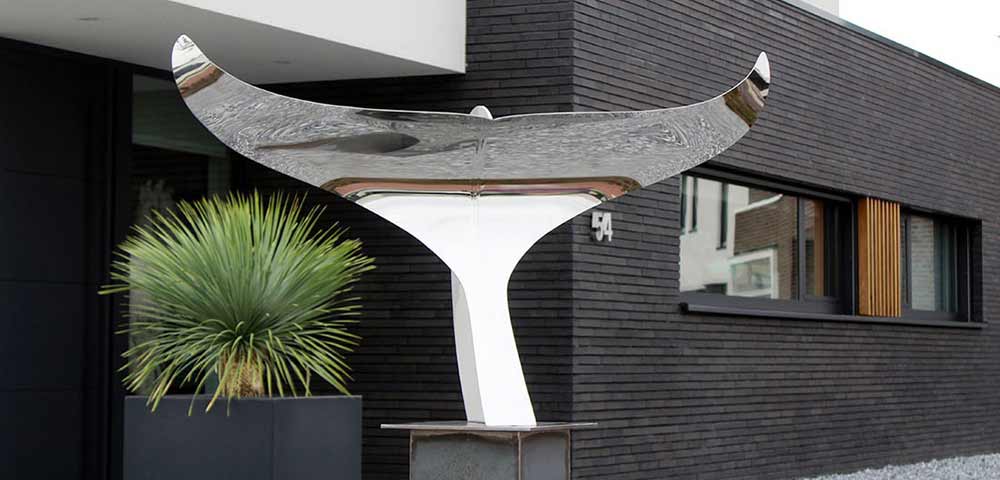 strak modern kunstwerk van rvs bij entree villa