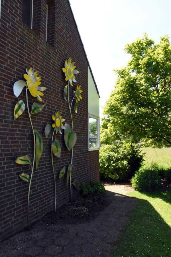 sculptuur aan muur zonnebloemen