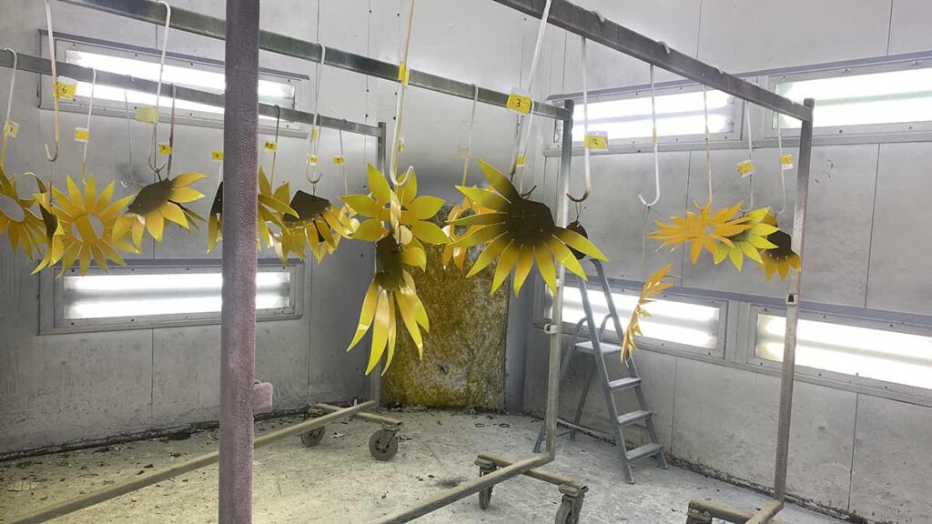 spuiten van de rvs- sculptuur zonnebloemen-wandsculptuur